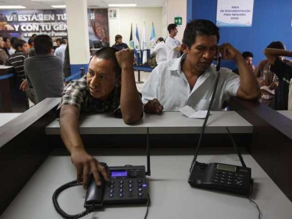 Los deportados pueden hacer llamadas de teléfono al llegar al aeropuerto de la Ciudad de Guatemala.