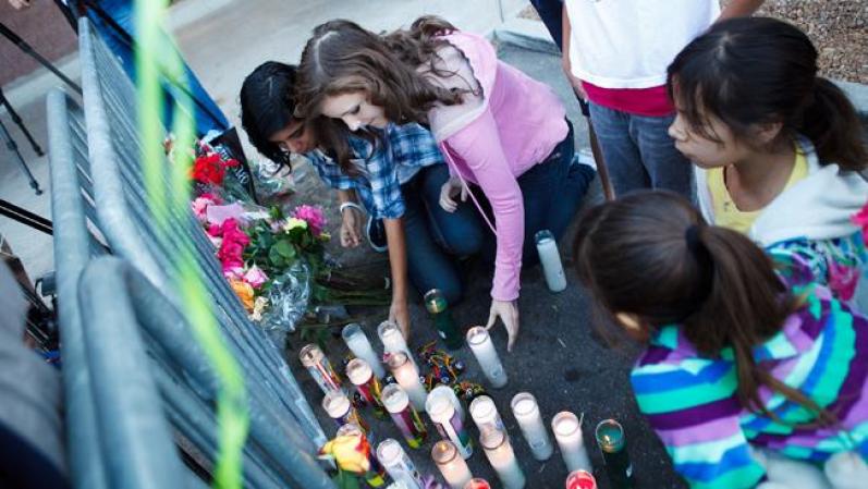 Flores y velones decoran una de las cercas que marcan el lugar donde ocurrió la masacre.