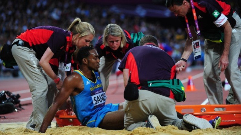El trágico accidente de Leevan Sands, el atleta de Bahamas se rompió la rodilla durante su último salto. Necesito ayuda médica para salir del estadio.