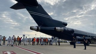 Migrantes hondureños abordan vuelo de regreso a casa
