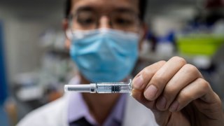 In this picture taken on April 29, 2020, an engineer shows an experimental vaccine for COVID-19 that was tested at the Quality Control Laboratory at the Sinovac Biotech facilities in Beijing.