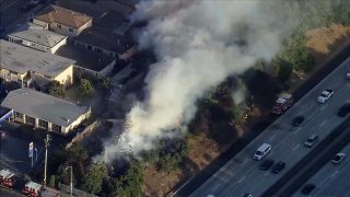 A brush fire burns along Interstate 580 in Oakland.