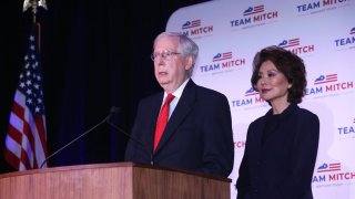 El senador republicano estadounidense Mitch McConnell de Kentucky (L) acompañado de su esposa Elaine Chao (R) mientras habla en una conferencia de prensa luego de su proyectada victoria en la carrera por el Senado en el Hotel Omni en Louisville, Kentucky, EE. UU., 03 de noviembre de 2020.