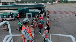 Ciudadanos hondureños suben a un avión para volver a casa, desde México