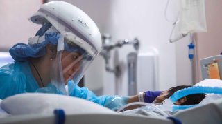 In this Jan. 3, 2021, file photo, registered nurse Yeni Sandoval wears personal protective equipment (PPE) while she cares for a COVID-19 patient in the Intensive Care Unit (ICU) at Providence Cedars-Sinai Tarzana Medical Center in Tarzana, California.