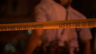 Philadelphia police officers behind yellow crime tape