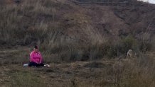 A woman with a platter of meat sits on the ground on Bernal Hill in San Francisco, Calif.