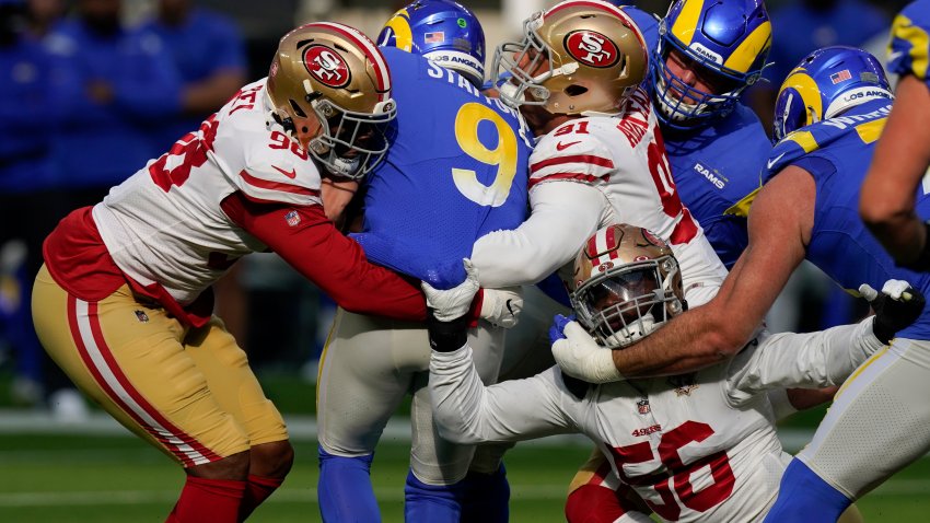 El quarterback de los Rams de Los Ángeles Matthew Stafford es capturado por Arden Key (98), Arik Armstead (91) y Samson Ebukam (56), de los 49ers de San Francisco, en la primera mitad del partido del domingo 9 de enero de 2022, en Inglewood, California. (AP Foto/Mark J. Terrill)