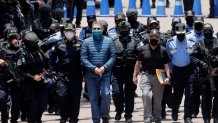 TEGUCIGALPA, HONDURAS - APRIL 21: Former President of Honduras Juan Orlando Hernandez is escorted by Members of the Police Special Forces to be extradited to U.S.to face charges of taking bribes from drug traffickers at Honduran National Directorate of Special Forces on April 21, 2022 in Tegucigalpa, Honduras. Hernandez will stand trial for allegedly aiding the smuggling of hundreds of tons of cocaine to America (Photo by Jorge Cabrera/Getty Images)