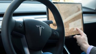 Foto del interior de un auto Tesla mostrando el volante y la pantalla.