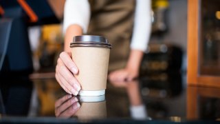 Woman pushes ahead coffee cup