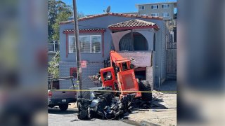 A construction vehicle crashes into a car and home in San Francisco.