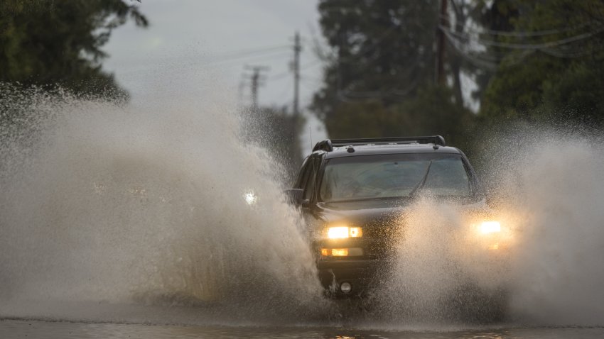 Cars drive through a flooded street in Watsonville, California, US, on Wednesday. Jan. 11, 2022. California faces more drenching rain as a historic drought has given way to flooding that’s killed at least 17 people, closed highways and sent residents fleeing for their lives. Photographer: Nic Coury/Bloomberg via Getty Images