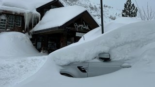 Snow covers a car at Palisades Tahoe.