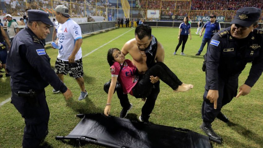 TOPSHOT – Supporters are helped by others following a stampede during a football match between Alianza and FAS at Cuscatlan stadium in San Salvador, on May 20, 2023. Nine people were killed May 20, 2023 in a stampede at an El Salvador stadium where soccer fans had gathered to watch a local tournament, police said. (Photo by Milton FLORES / AFP) (Photo by MILTON FLORES/AFP via Getty Images)