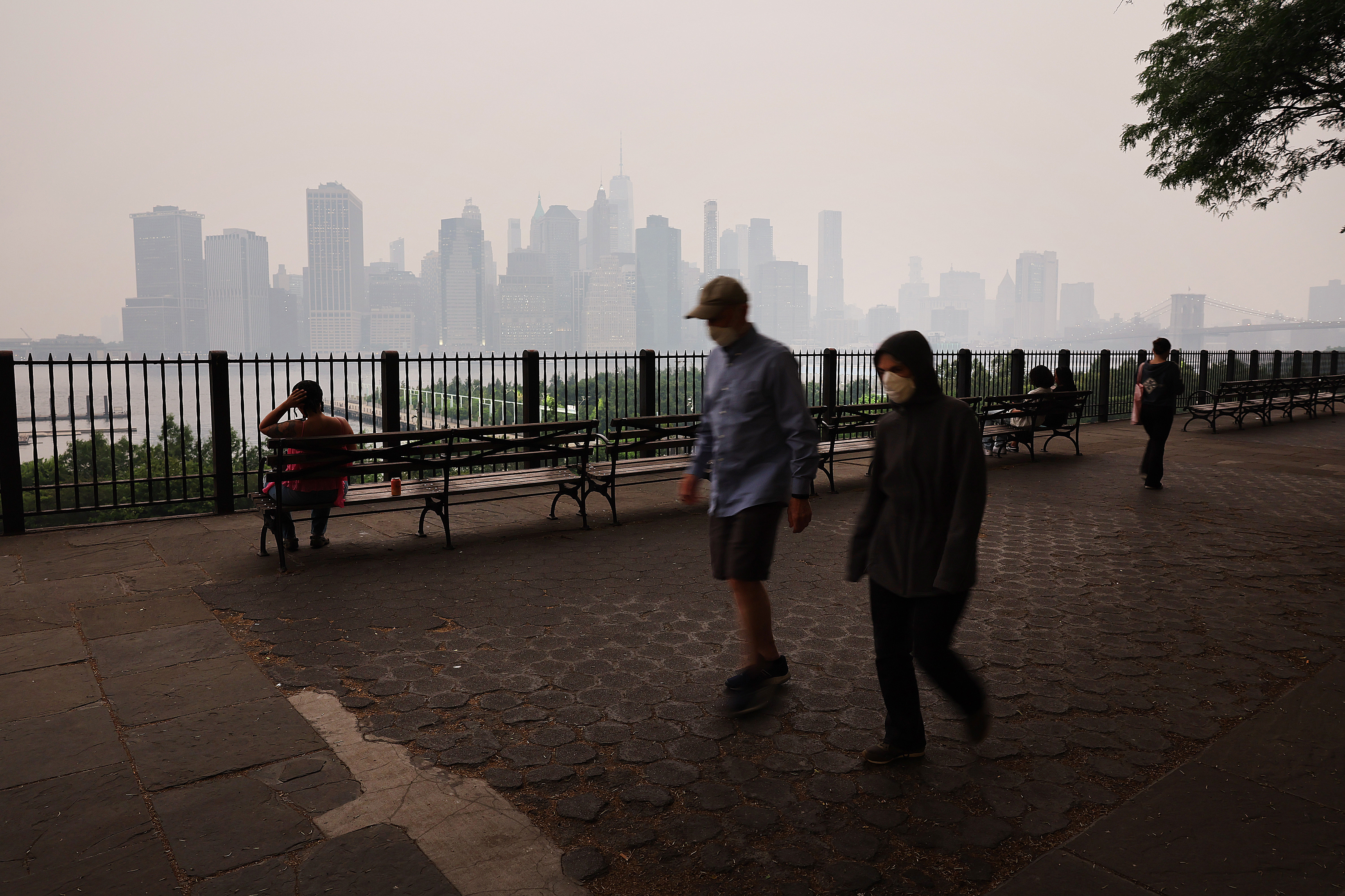 NUEVA YORK, NUEVA YORK – 6 DE JUNIO: La gente camina por el paseo marítimo de Brooklyn mientras una neblina rojiza envuelve el horizonte de Manhattan como resultado de los incendios forestales canadienses el 6 de junio de 2023 en la Ciudad de Nueva York. Más de 100 incendios forestales están ardiendo en la provincia canadiense de Nueva Escocia y Quebec, lo que genera alertas de salud sobre la calidad del aire para las Adirondacks, el este del lago Ontario, el centro de Nueva York y el oeste de Nueva York. (Foto de Spencer Platt/Getty Images)