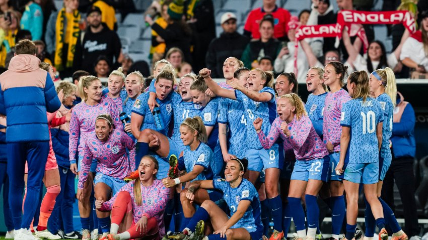 England's women's team in blue uniforms celebrating