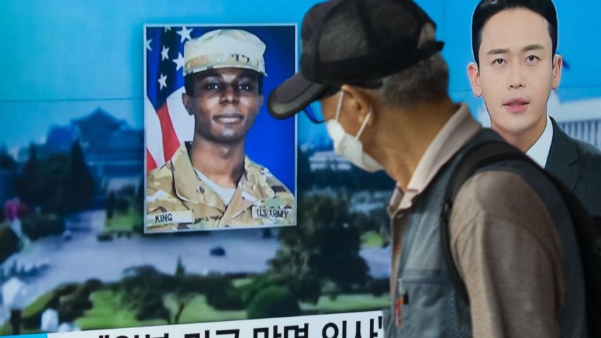 In this photo taken in Seoul on August 16, 2023, a man walks past a television showing a news broadcast featuring a photo of US soldier Travis King (C), who ran across the border into North Korea while part of a tour group visiting the Demilitarized Zone on South Korea’s border on July 18. Travis King defected to North Korea to escape “mistreatment and racial discrimination in the US Army”, state media said Wednesday, Pyongyang’s first official confirmation they were holding the American soldier. (Photo by Anthony WALLACE / AFP) (Photo by ANTHONY WALLACE/AFP via Getty Images)