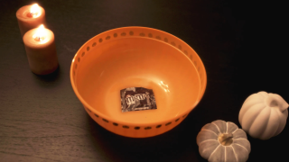 A candy bowl with only one individual bag of M&Ms.