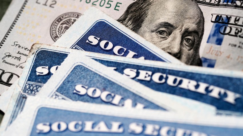 Several Social Security Cards on a US United States one hundred dollar bill $100 system of benefits for retired elderly people