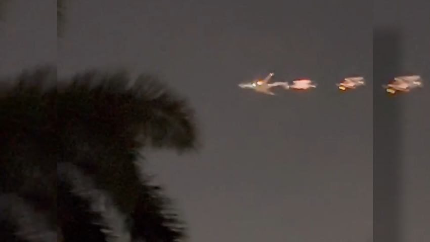 Plane on fire flies across night sky