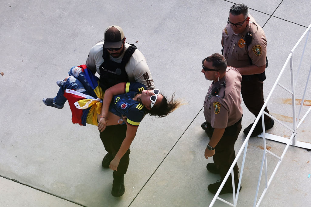 Un policía carga a un aficionado inconsciente durante el partido final de la Copa América CONMEBOL 2024 entre Argentina y Colombia en el Hard Rock Stadium el 14 de julio de 2024 en Miami Gardens, Florida.