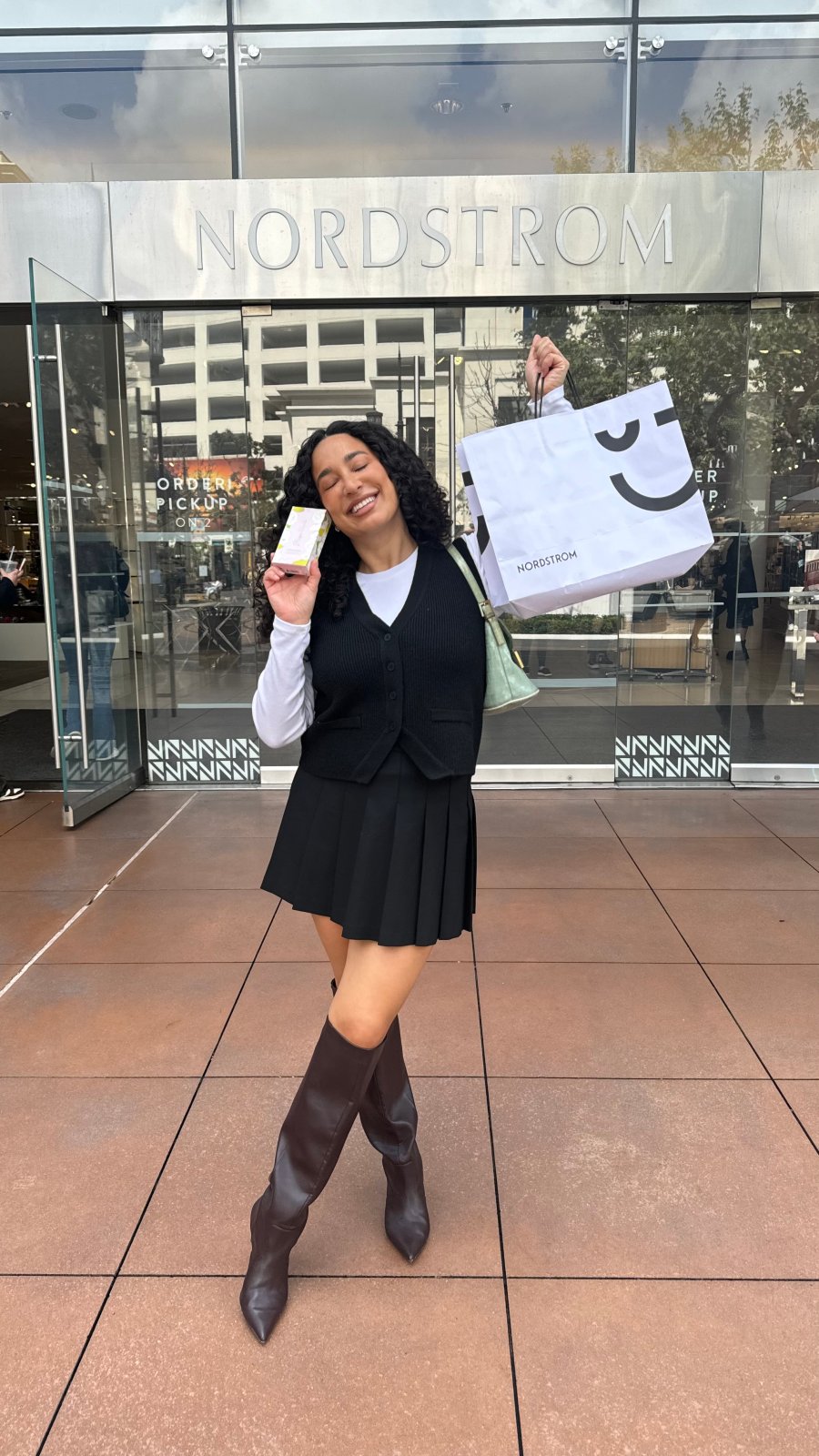 Julisa Prado holds a bag of Rizos Curls outside of a Nordstrom store.