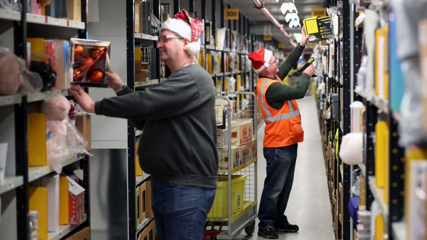 El personal recorre los pasillos recogiendo artículos antes de enviarlos a la sala de expedición para su empaquetado en uno de los mayores almacenes británicos de Amazon en Dunfermline, Fife, mientras el gigante de las compras online se prepara para la fiebre navideña y las próximas rebajas del Black Friday. (Foto de Jane Barlow/PA Images vía Getty Images)