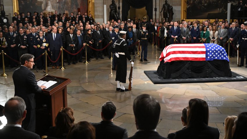 US Speaker of the House Mike Johnson (L) speaks as a military guard of honor stands next to the flag-draped casket of former US President Jimmy Carter at the US Capitol Rotunda, where he lies in state, in Washington, DC, on January 7, 2025. Carter, the 39th President of the United States, died at the age of 100 on December 29, 2024 at his home in Plains, Georgia. (Photo by SAUL LOEB / POOL / AFP) (Photo by SAUL LOEB/POOL/AFP via Getty Images)