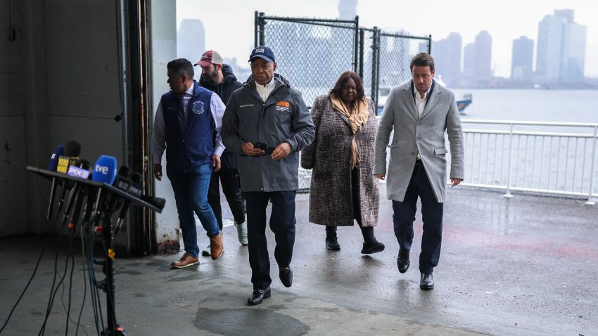 El alcalde de Nueva York, Eric Adams (2º izda.), y Joan Camprubi (dcha.), hermano de la madre fallecida en el accidente, llegan para hablar durante una rueda de prensa tras el accidente de un helicóptero en el río Hudson, en el muelle 40 de Nueva York, el 12 de abril de 2025.