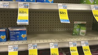 A store shelf filled with some allergy medicatiions.