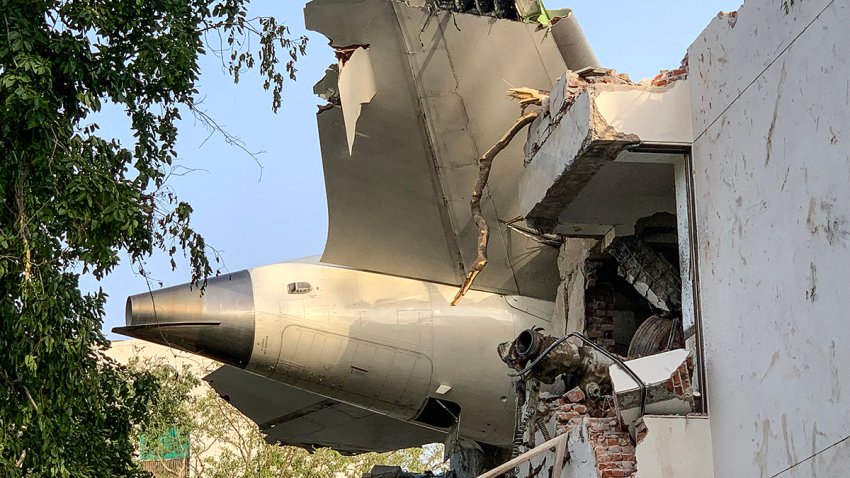 The back of Air India flight 171 is pictured at the site after it crashed in a residential area near the airport in Ahmedabad on June 12, 2025. A London-bound passenger plane crashed in the Indian city of Ahmedabad on June 12 and all 242 people on board were believed killed, with the jet smashing into buildings housing doctors and their families. (Photo by Sam PANTHAKY / AFP) (Photo by SAM PANTHAKY/AFP via Getty Images)