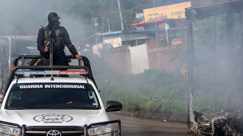 A police patrol crosses a barricade set up by residents to pressure for the release of seven indigenous police officers allegedly kidnapped by hitmen from organised crime in Santiago Tangamandapio, Michoacan State, Mexico on August 23, 2024. According to the Prosecutor’s Office, the community police officers were kidnapped on August 20 and rescued today amid protests by residents who burned vehicles and blocked roads to pressure their release. (Photo by Enrique Castro / AFP) (Photo by ENRIQUE CASTRO/AFP via Getty Images)