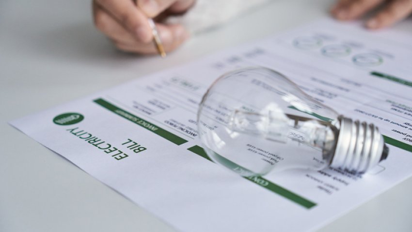 Close up view of a person checking electricity bill at home. Electricity, finance and bills concept.